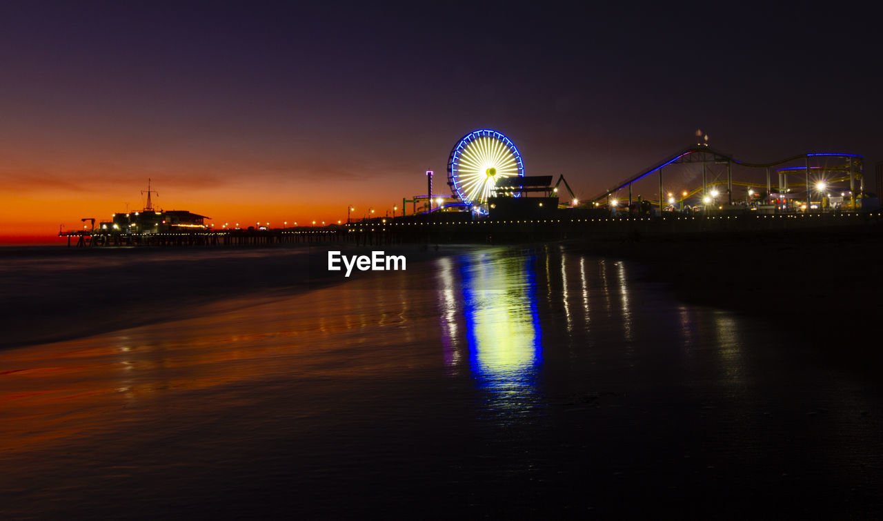 Illuminated ferris wheel by on santa monica pier