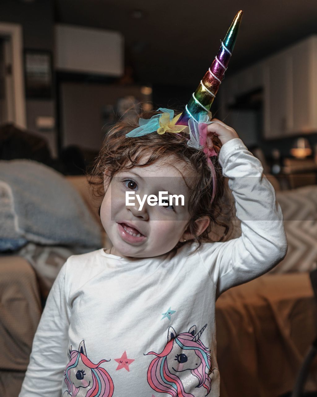 Portrait of cute girl wearing unicorn hat while standing at home