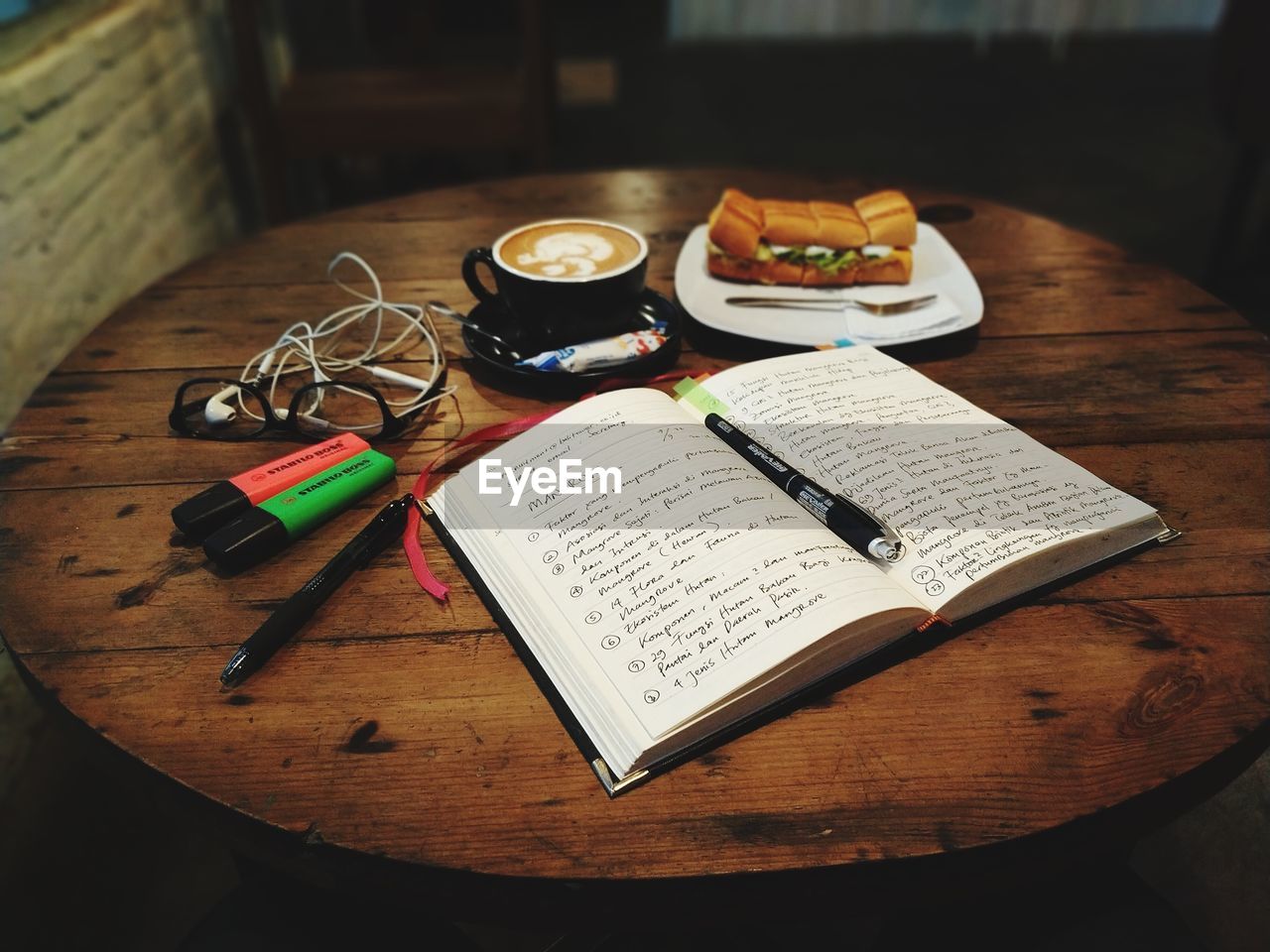 table, indoors, book, publication, paper, wood, food and drink, art, still life, no people, high angle view, handwriting, food, music, pen