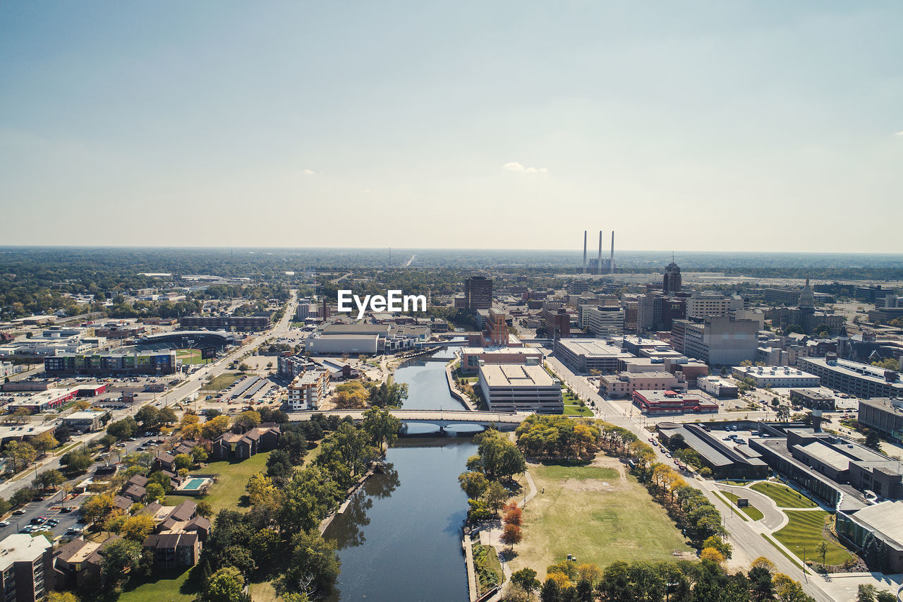 Aerial view of cityscape against sky during sunny day