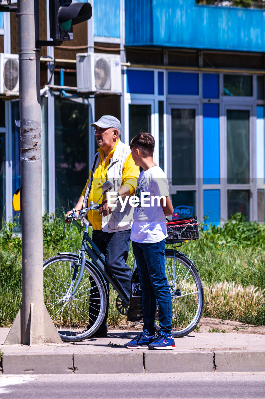 FULL LENGTH OF A MAN WITH BICYCLE ON ROAD