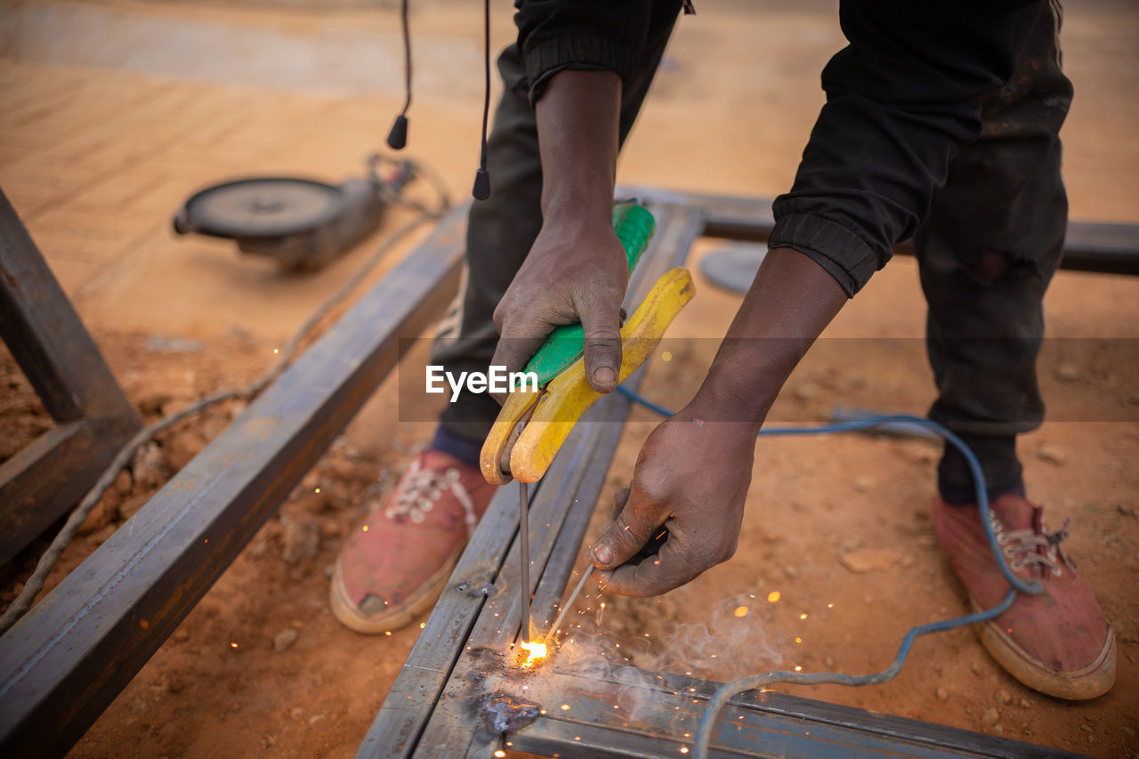 LOW SECTION OF MAN WORKING ON WOOD AT