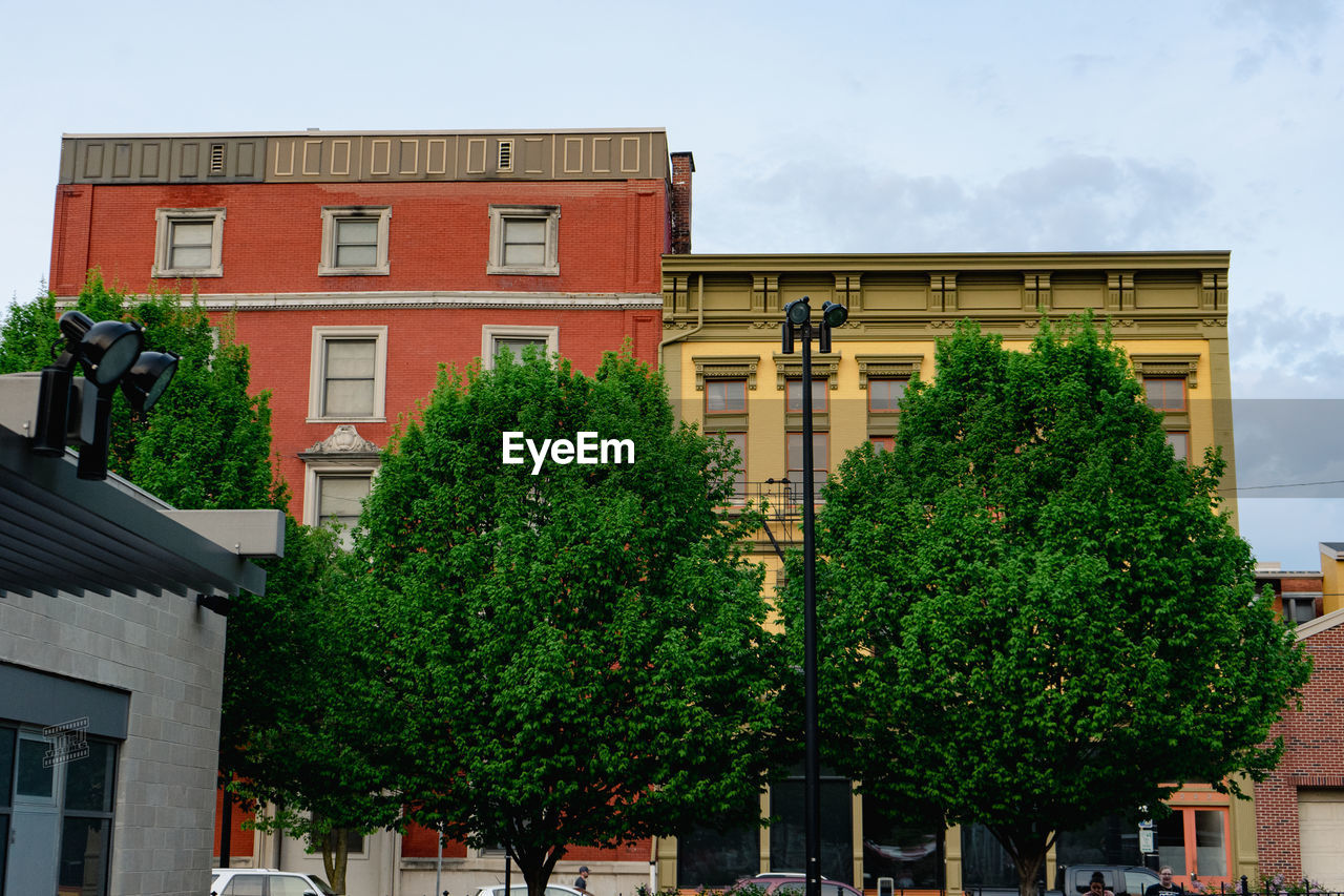 architecture, building exterior, neighbourhood, built structure, tree, city, plant, downtown, building, residential area, town, urban area, facade, nature, sky, street, residential district, motor vehicle, car, house, day, transportation, mode of transportation, outdoors, no people, land vehicle, road
