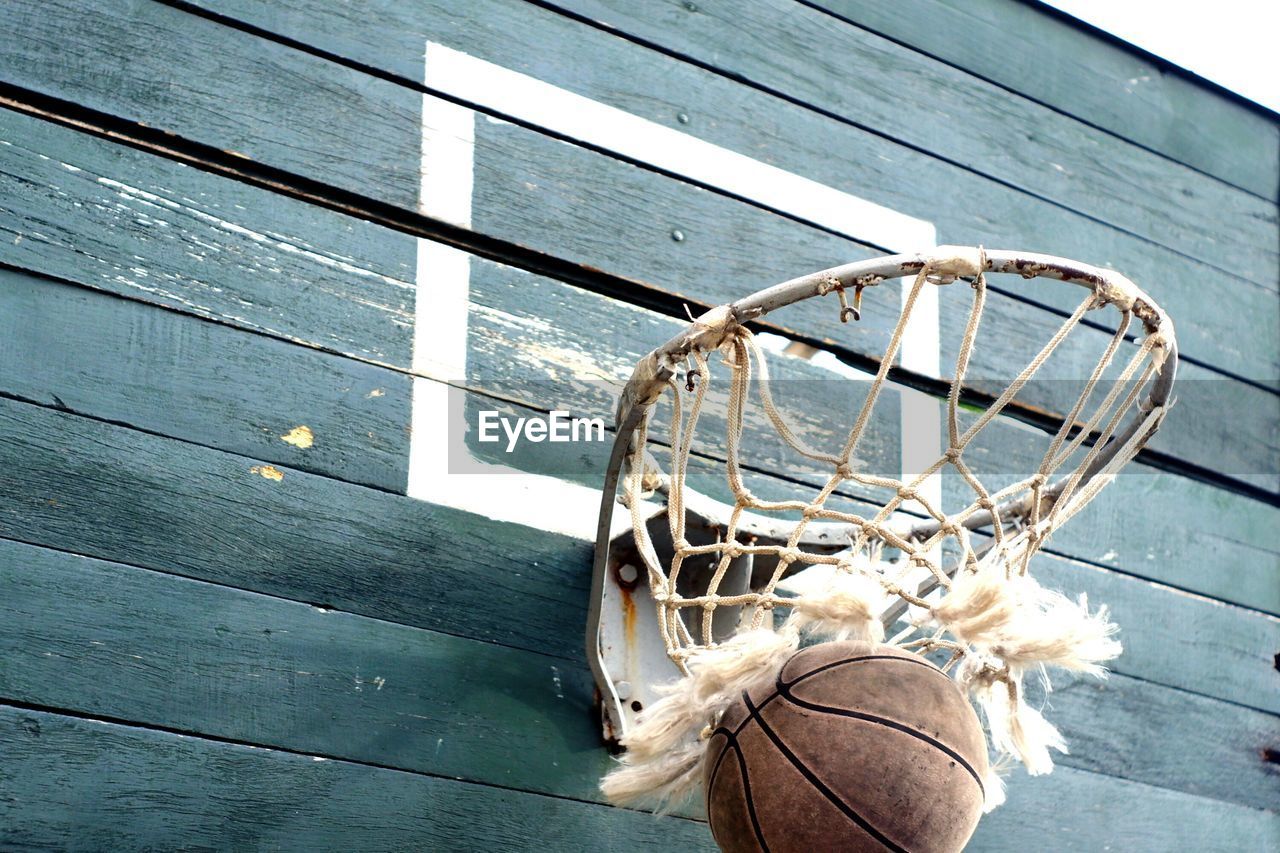 LOW ANGLE VIEW OF BASKETBALL HOOP ON WALL