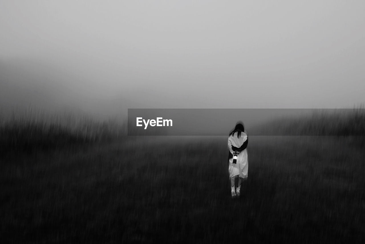 FULL LENGTH OF WOMAN STANDING ON FIELD