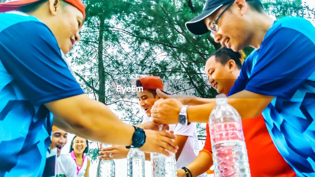 Low angle view of men playing with water bottles