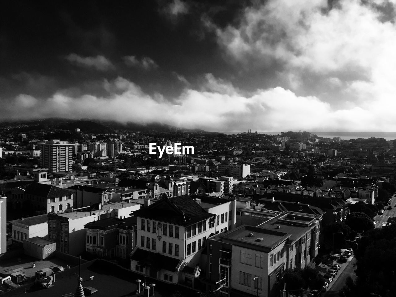 Buildings in town against cloudy sky