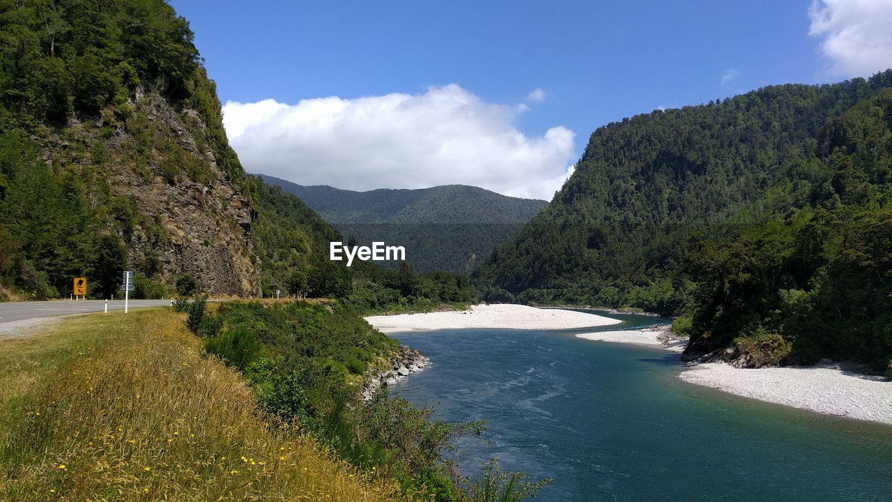 Scenic view of sea and mountains against sky