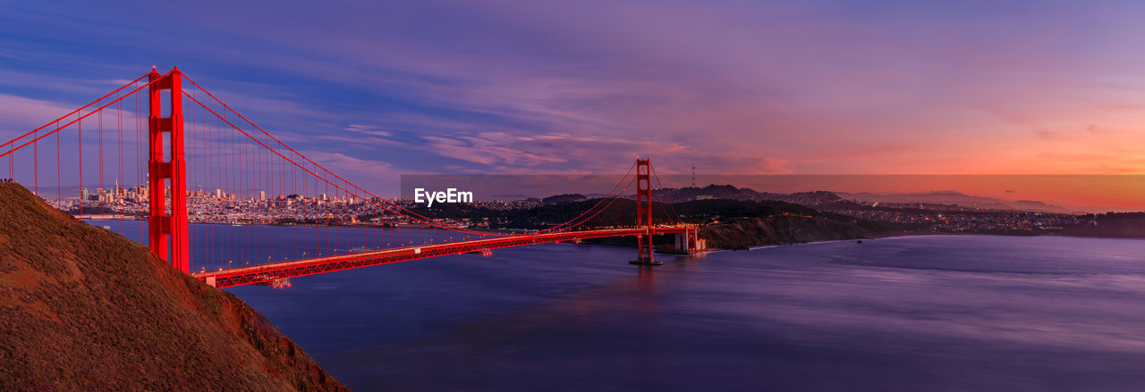 view of suspension bridge over river against sky during sunset