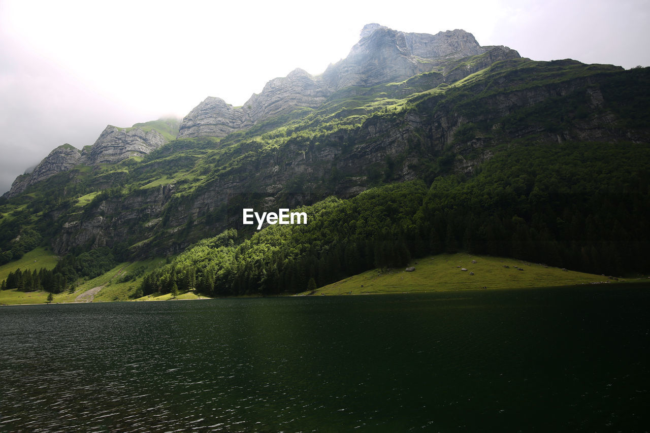 Scenic view of lake and mountains against sky