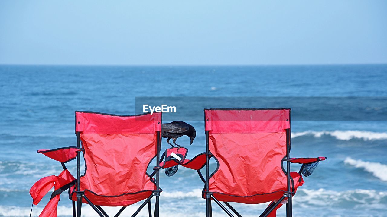 Red chairs against blue sea and clear sky