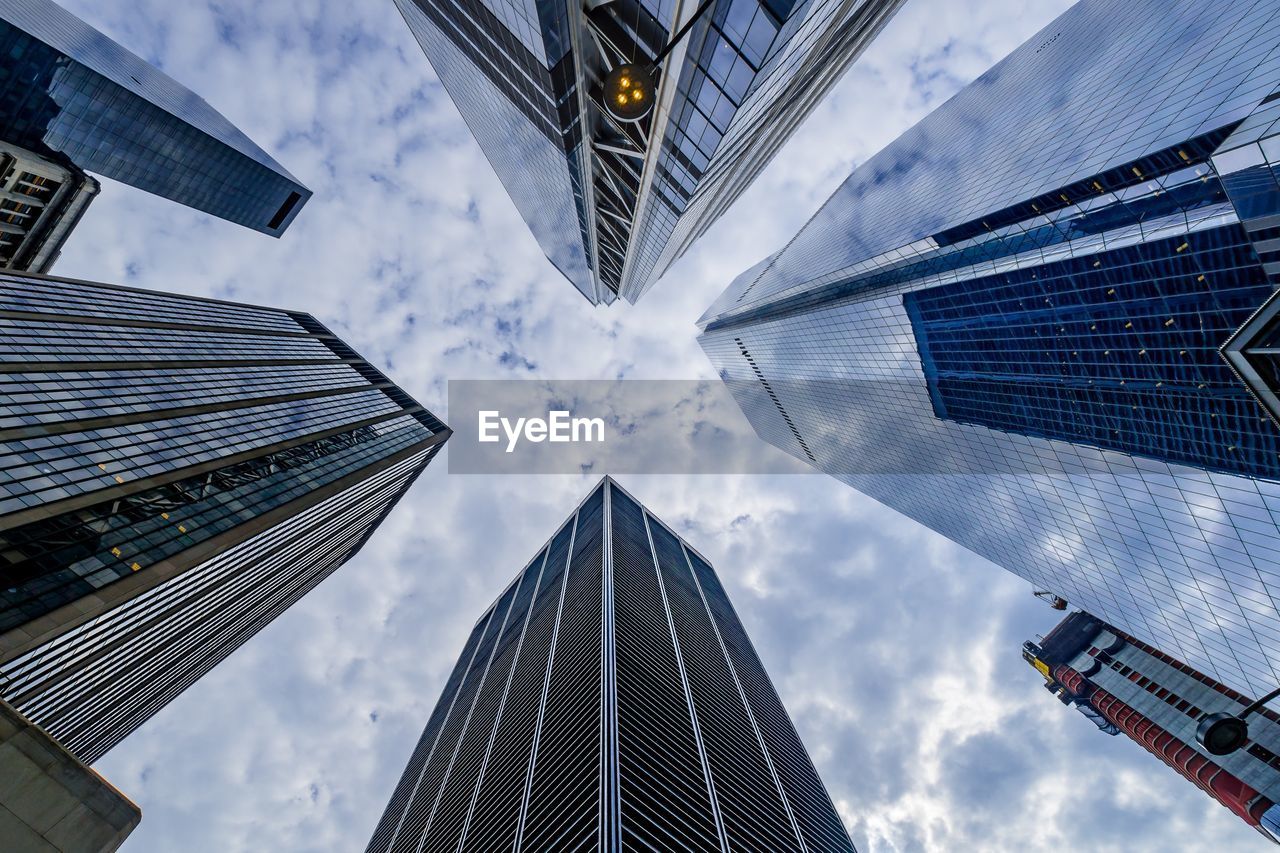 Low angle view of buildings against cloudy sky