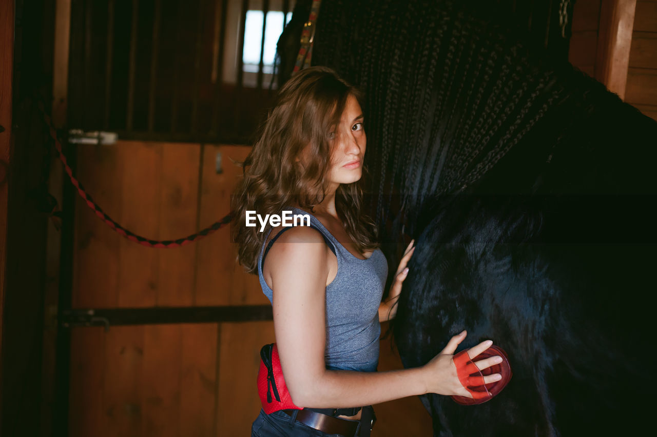 Woman with horse in stable