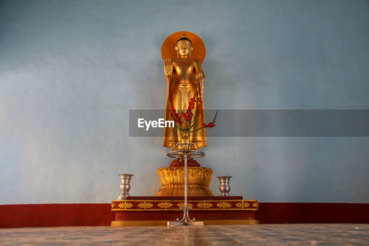 STATUE OF BUDDHA ON WALL AT TEMPLE