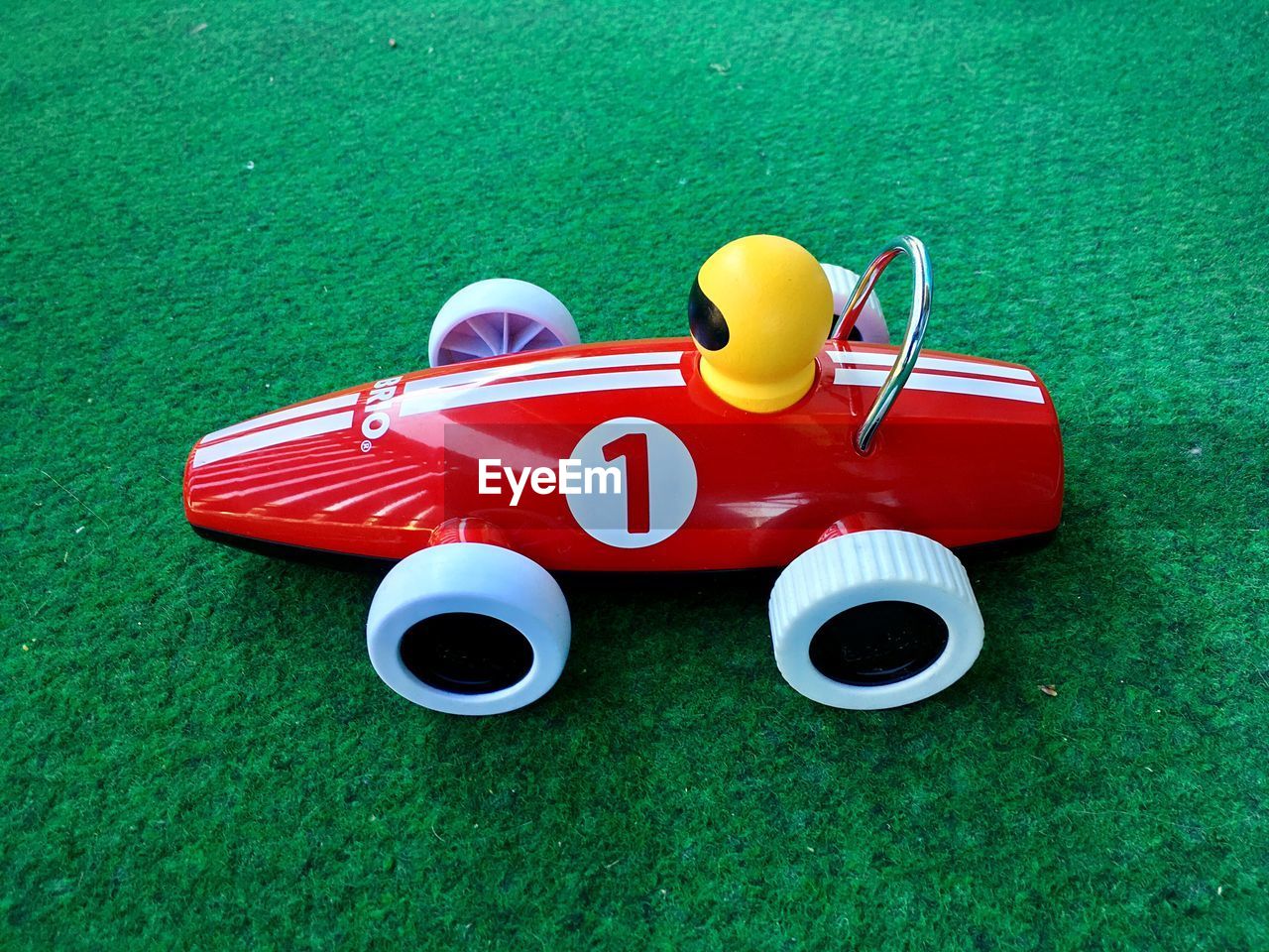 HIGH ANGLE VIEW OF TOY CAR ON GRASSY FIELD