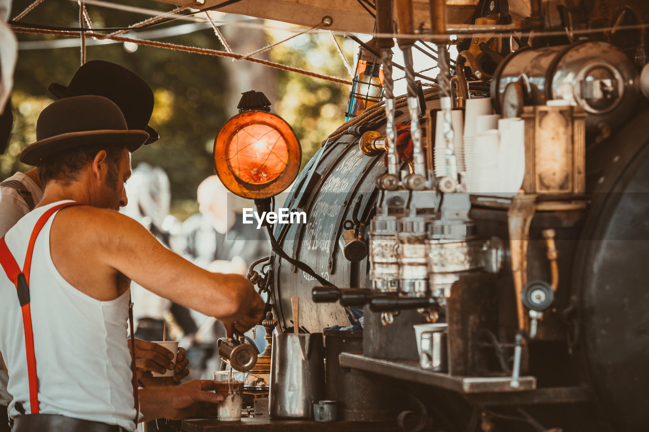 Side view of man preparing coffee