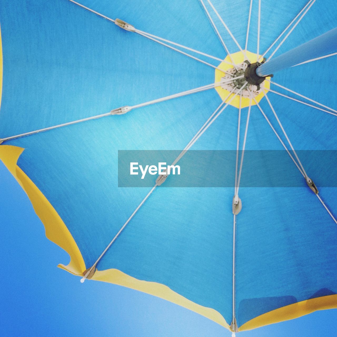 Low angle view of blue parasol against clear sky