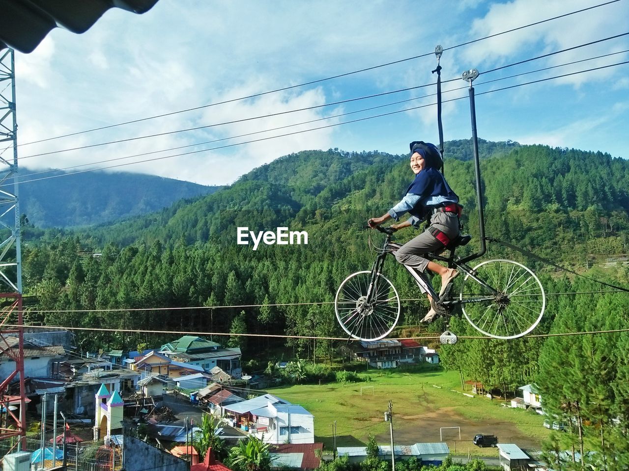 MAN RIDING BICYCLE AGAINST SKY