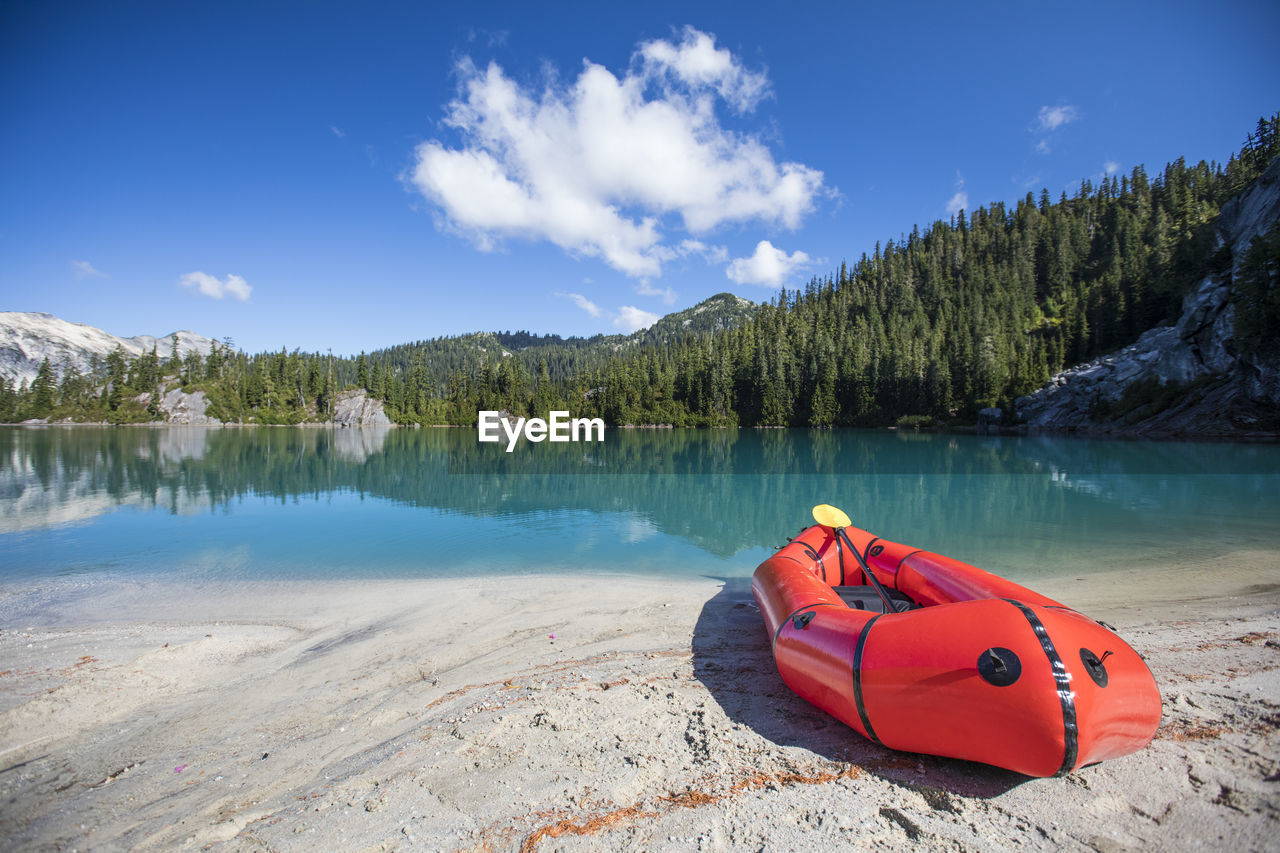 Paddle board on beach of remote mountain lake.