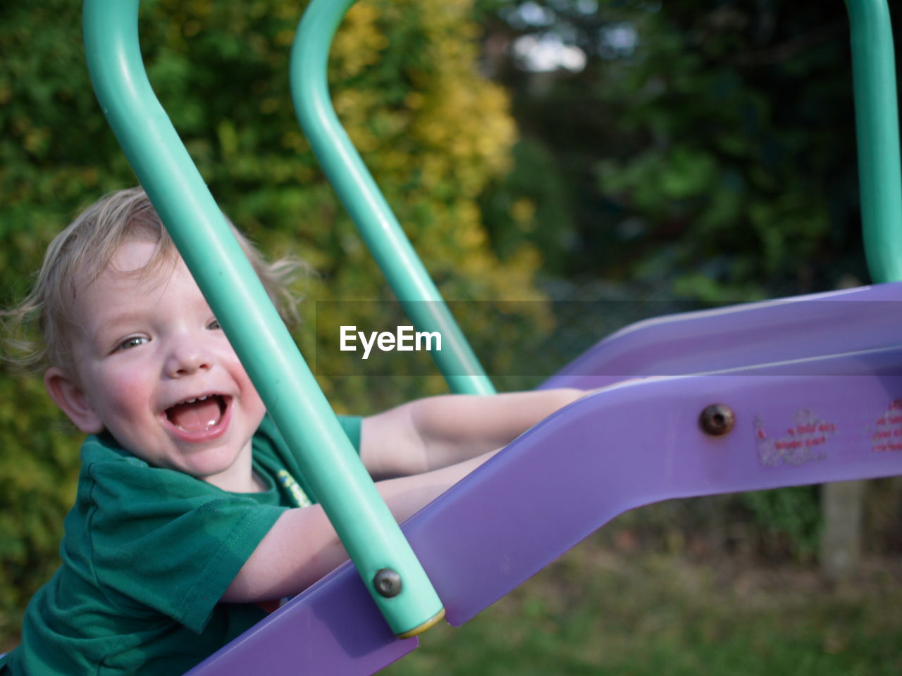 Portrait of cute baby boy on slide at playground