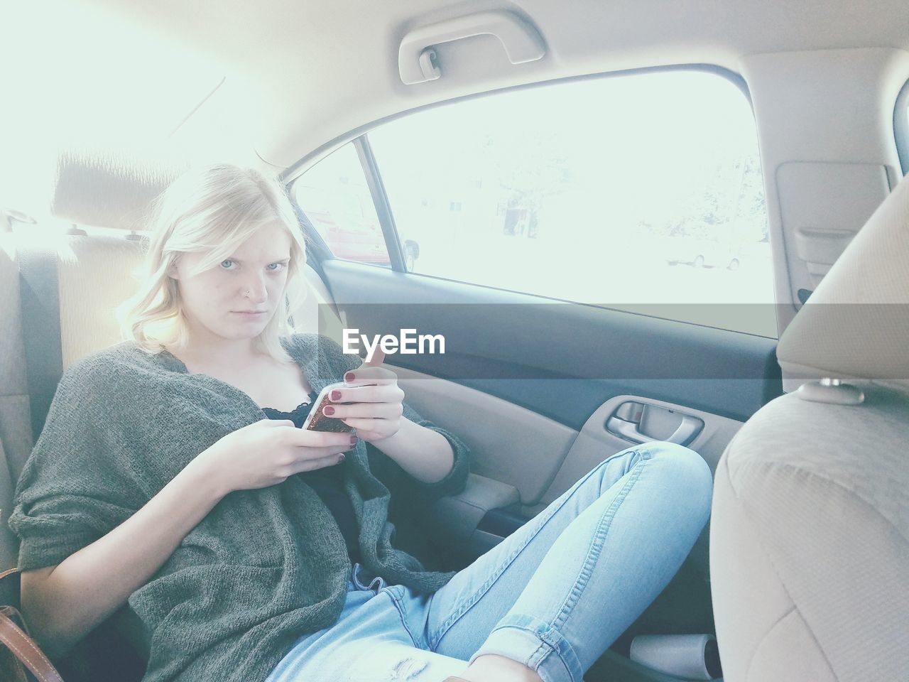 Portrait of woman using mobile phone in car