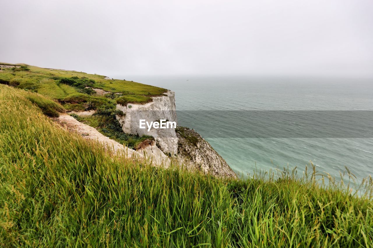 Scenic view of white cliffs of dover and sea against sky