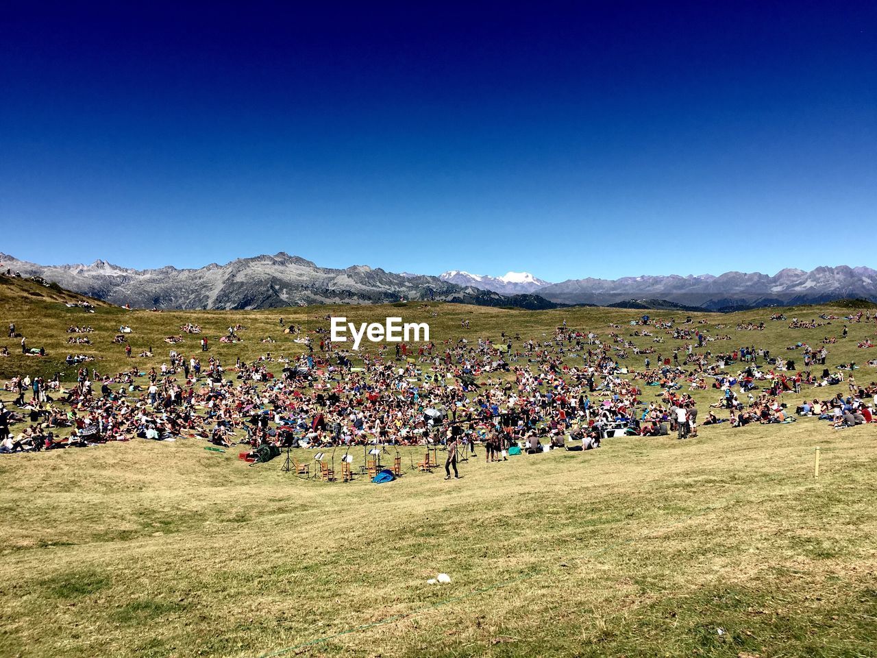 Crowd on landscape against blue sky