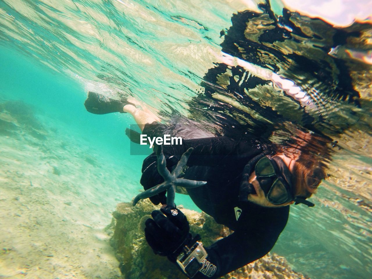 YOUNG WOMAN PHOTOGRAPHING THROUGH CAMERA