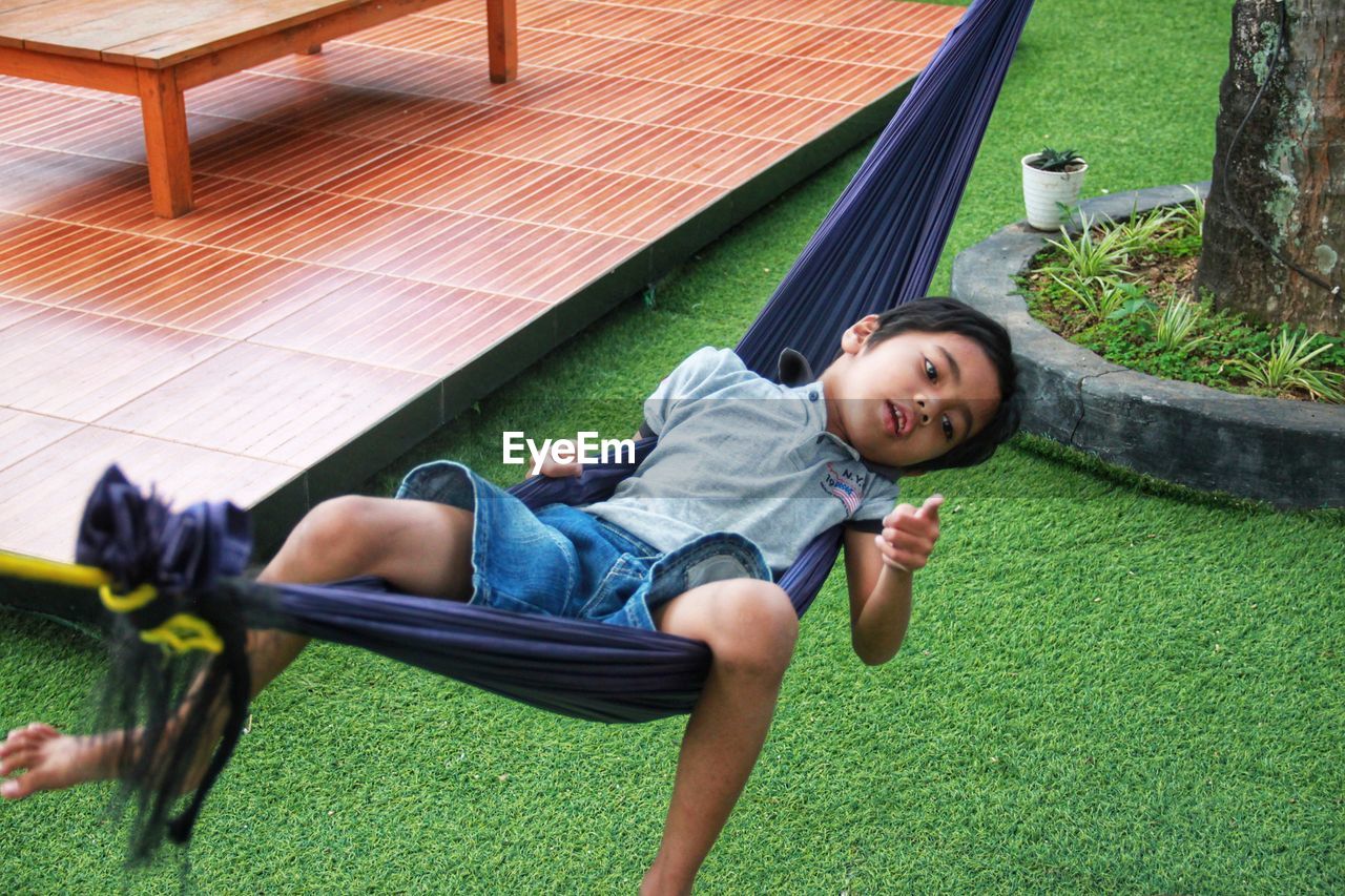 High angle view of siblings lying on grass