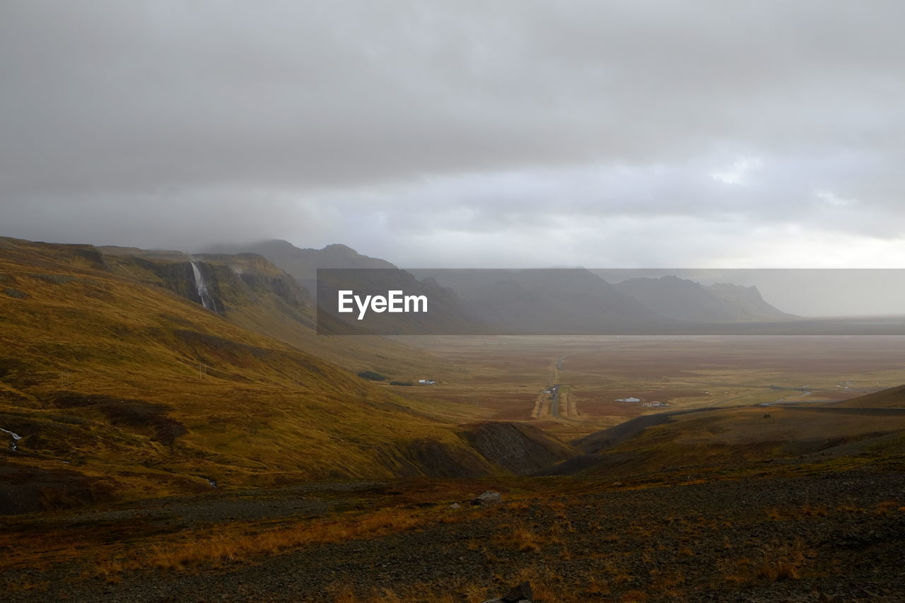 Scenic view of field and mountains against sky