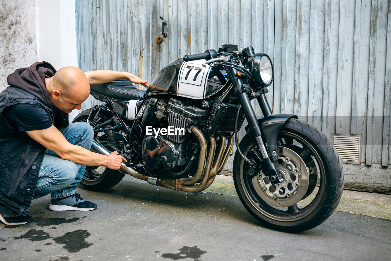 Mechanic repairing motorcycle on street