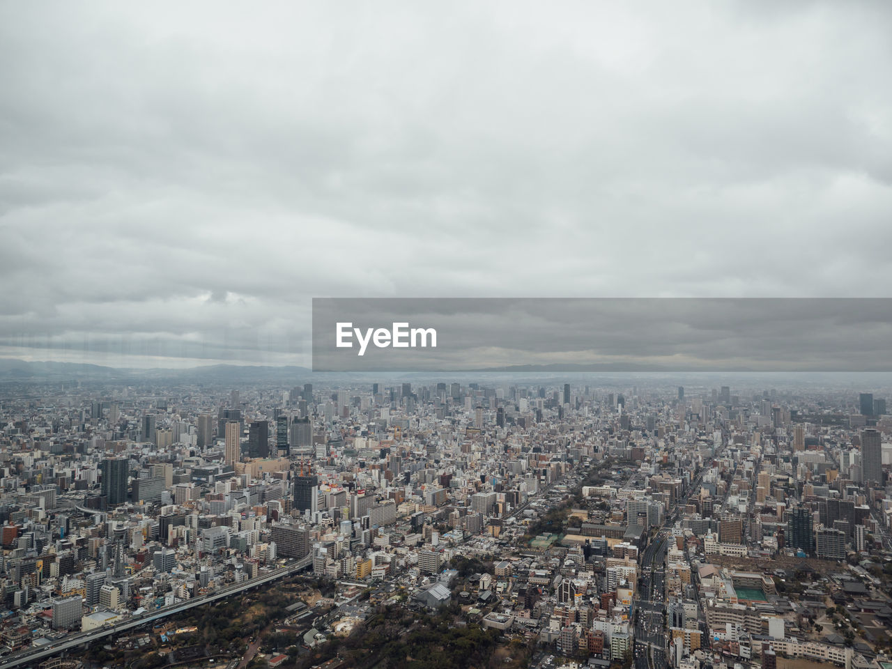 Aerial view of buildings in city against sky