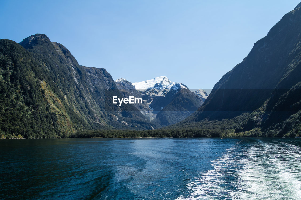 Scenic view of lake and mountains against clear sky