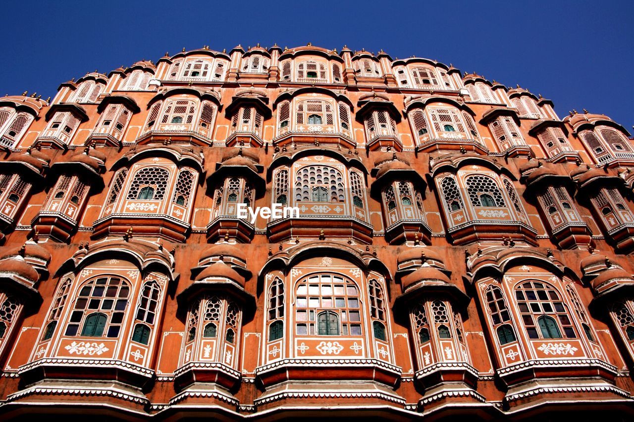 Low angle view of hawa mahal against clear blue sky during sunny day