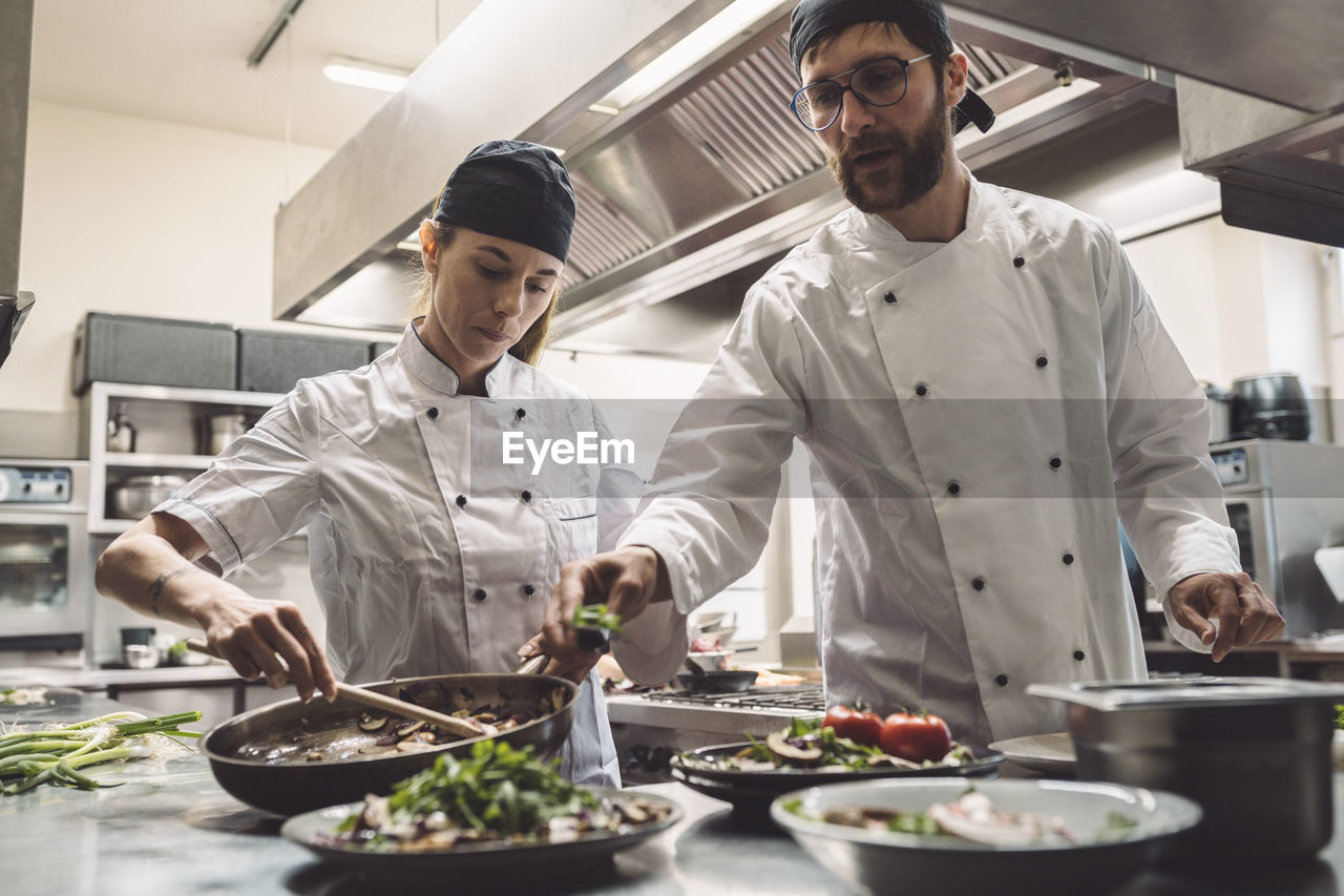 Low angle view of chefs preparing food in commercial kitchen