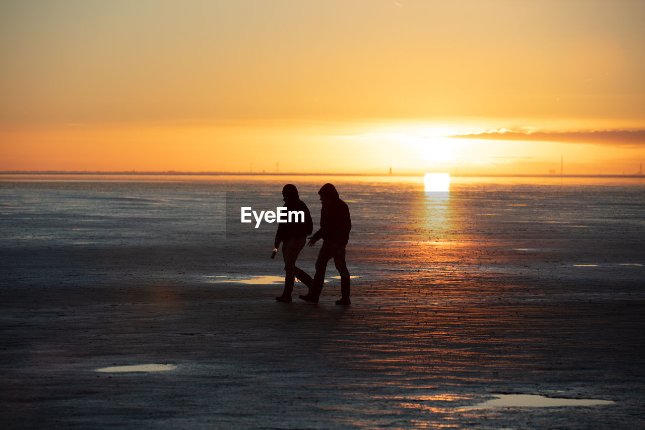 SILHOUETTE MEN ON BEACH DURING SUNSET