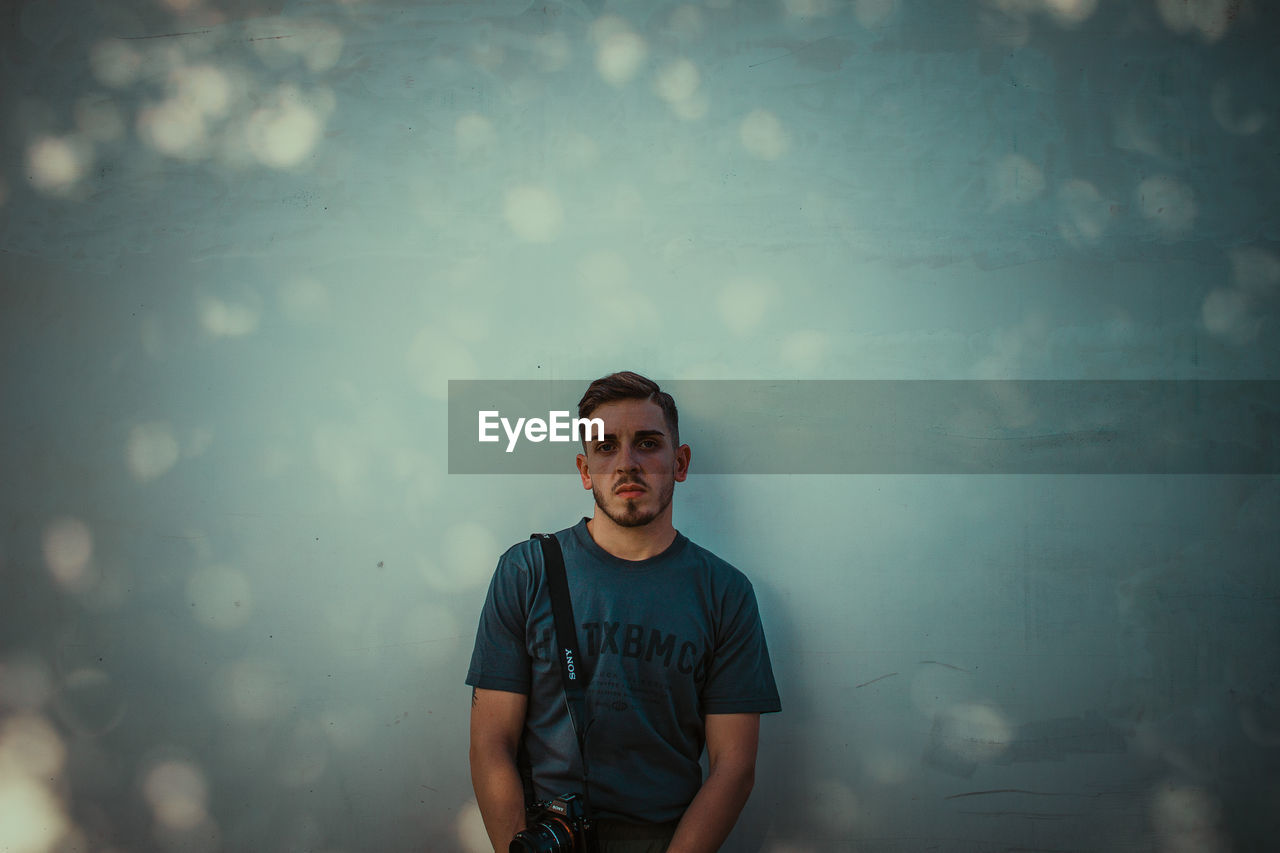 Portrait of young man against wall