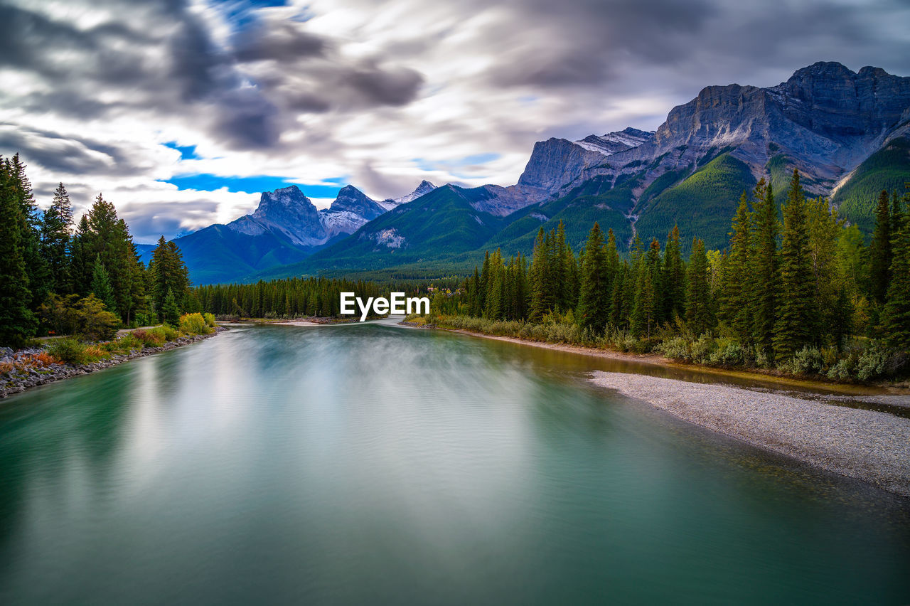 scenic view of river amidst mountains against sky