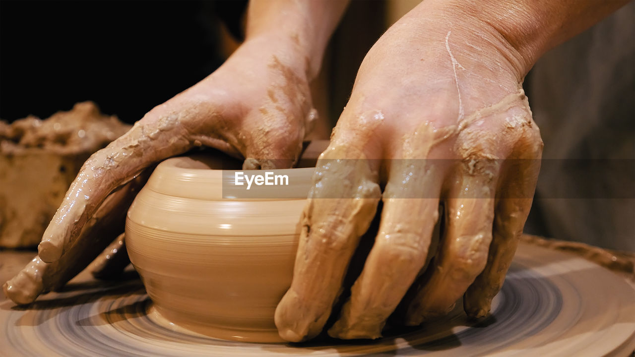 Close-up of person making pottery