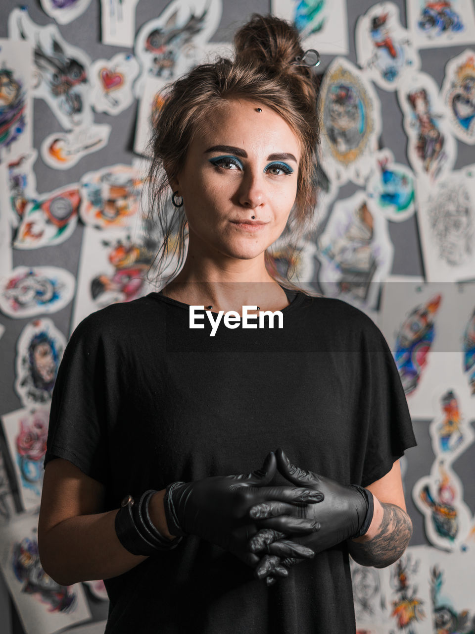 PORTRAIT OF WOMAN STANDING AGAINST WALL