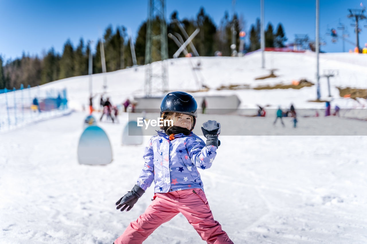 REAR VIEW OF CHILD ON SNOWY FIELD