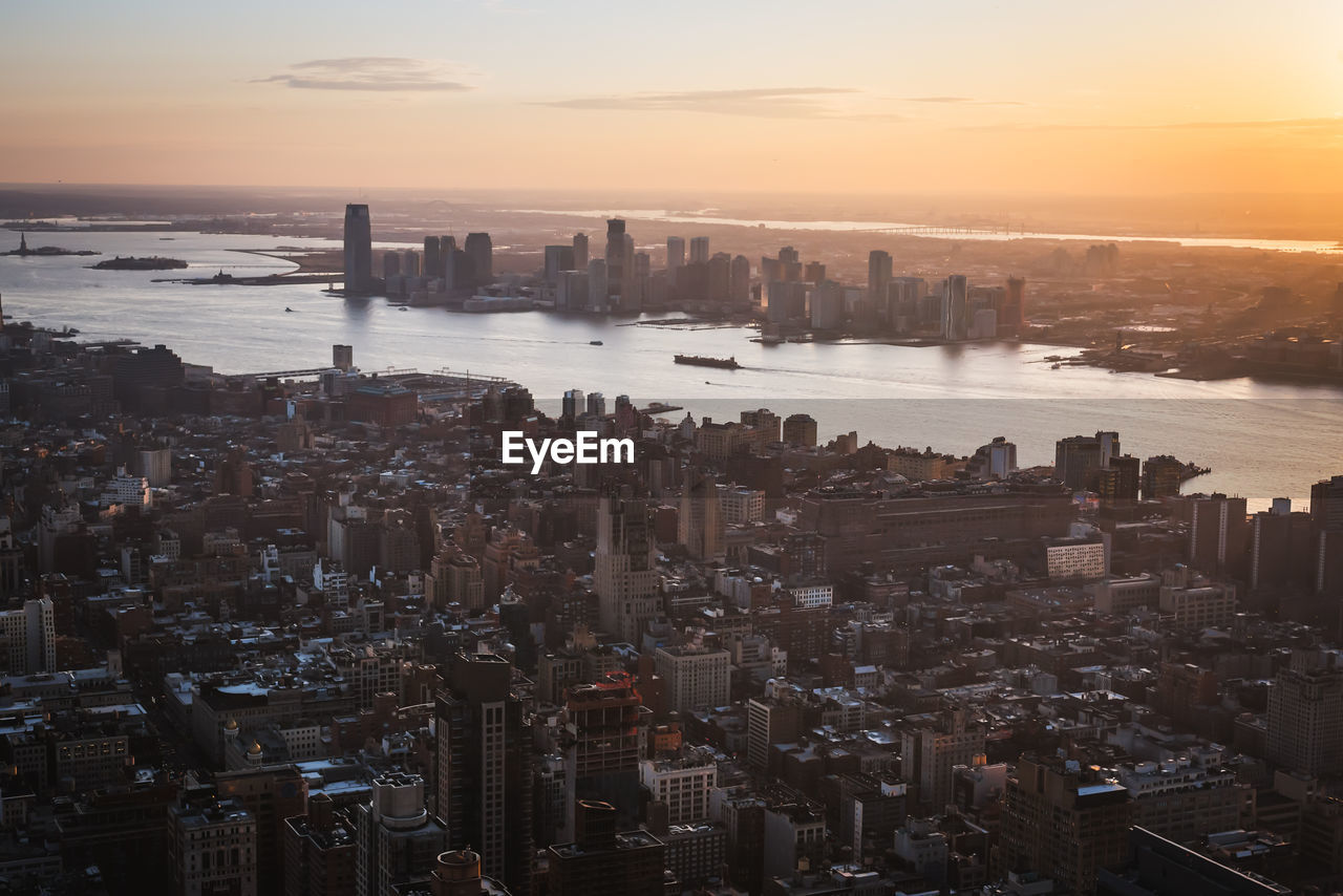 Aerial view of buildings in city during sunset