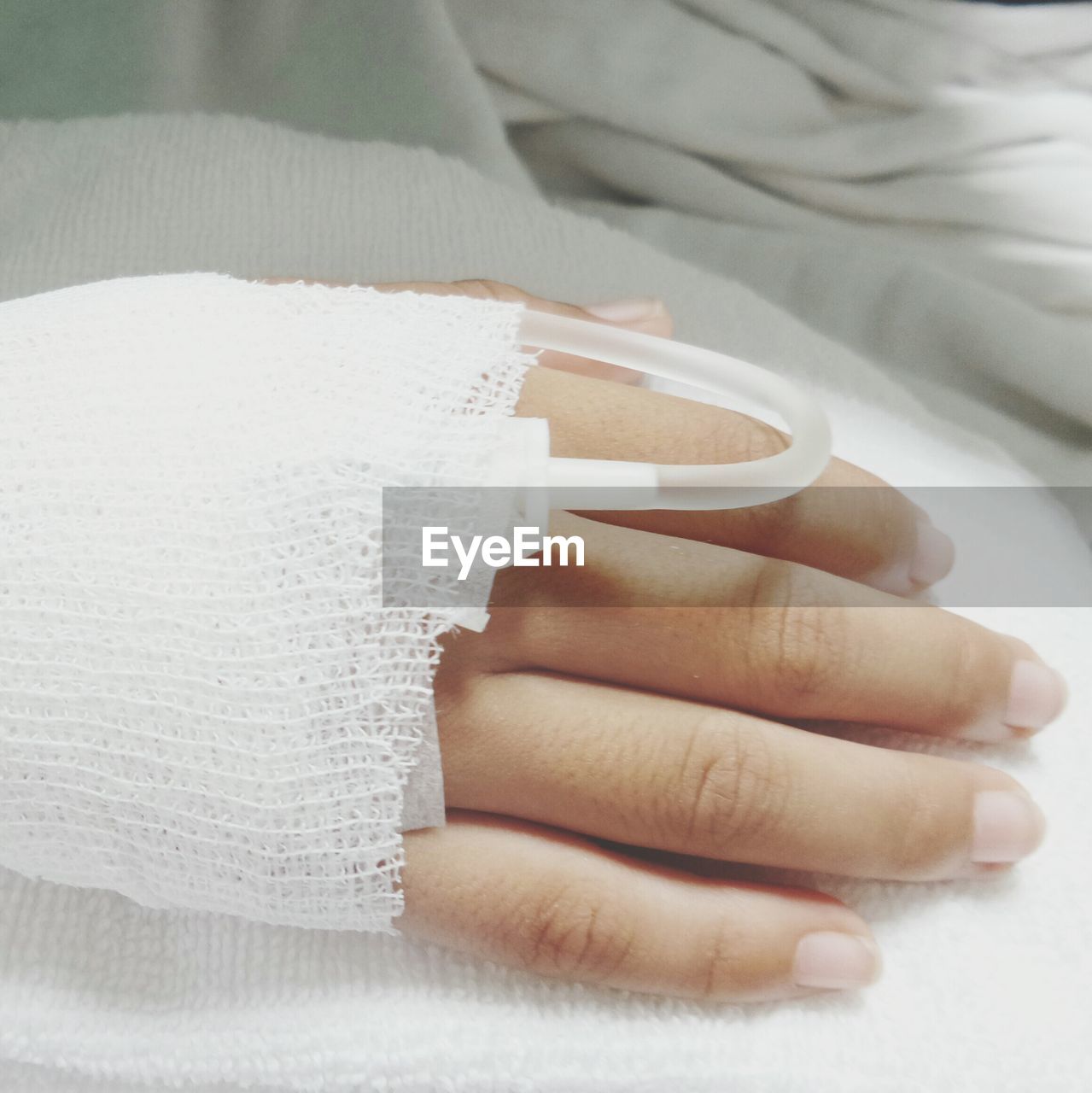 Cropped hand of woman with iv drip in hospital