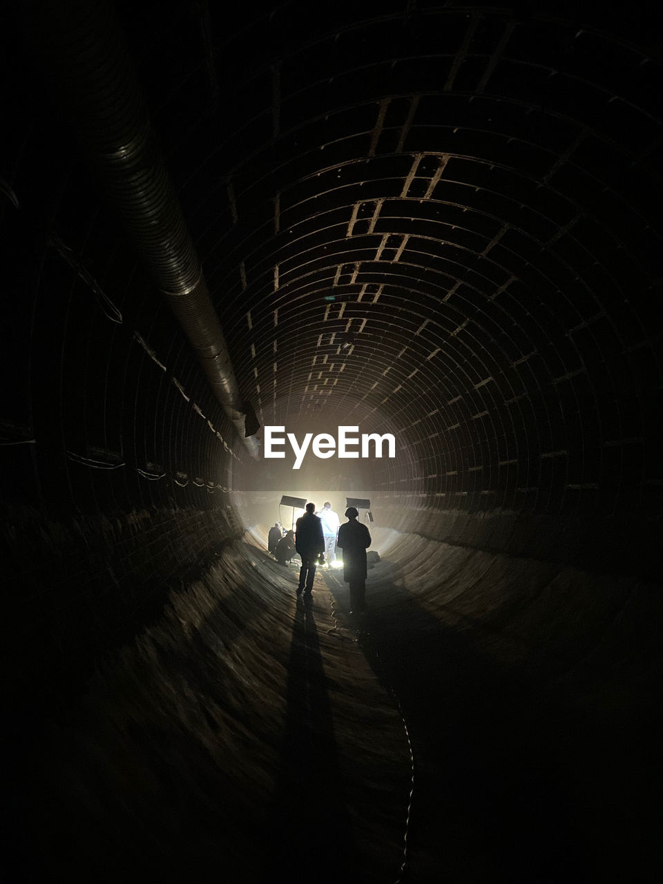 rear view of man standing in tunnel at night