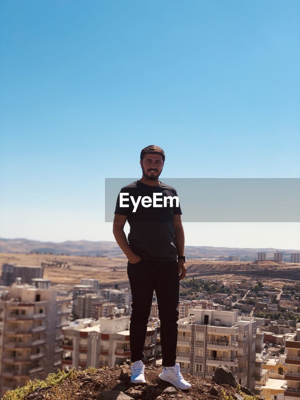 Portrait of man standing against cityscape