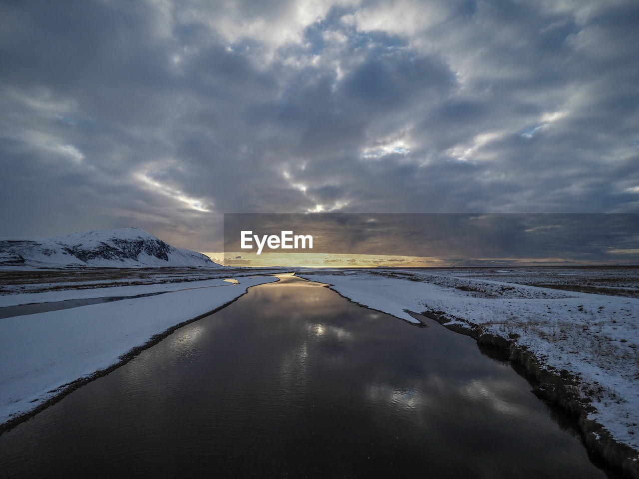 Scenic view of snow covered land against sky during winter