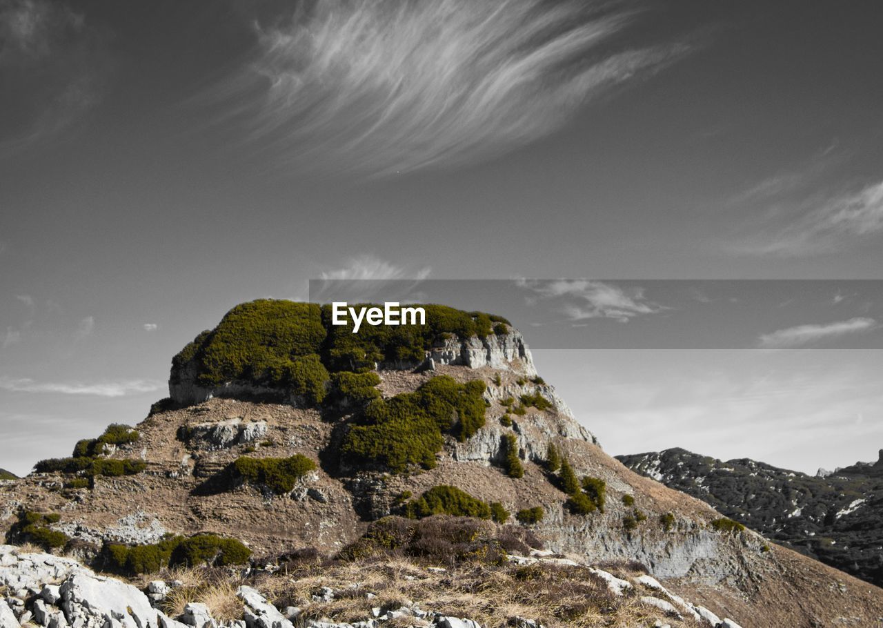 Low angle view of rocks on mountain against sky