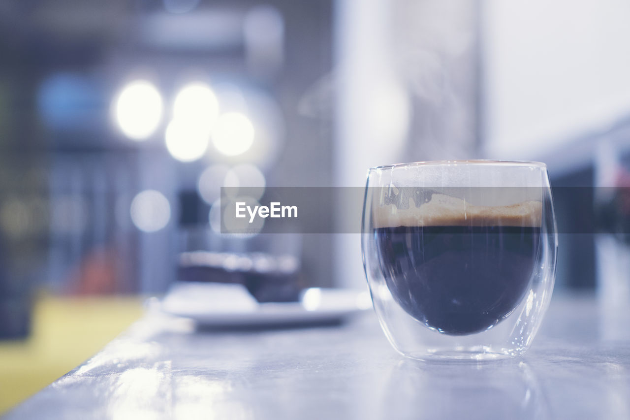 CLOSE-UP OF COFFEE IN GLASS