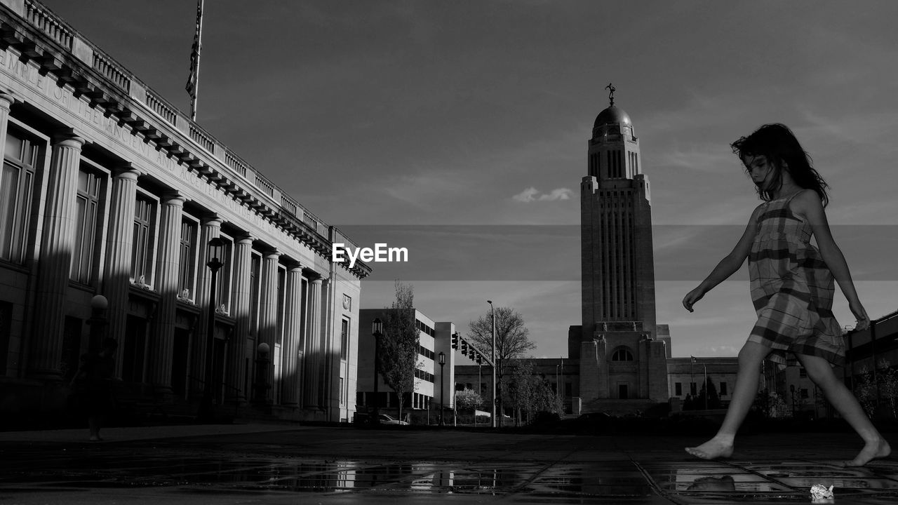 Girl standing against nebraska state capitol building 