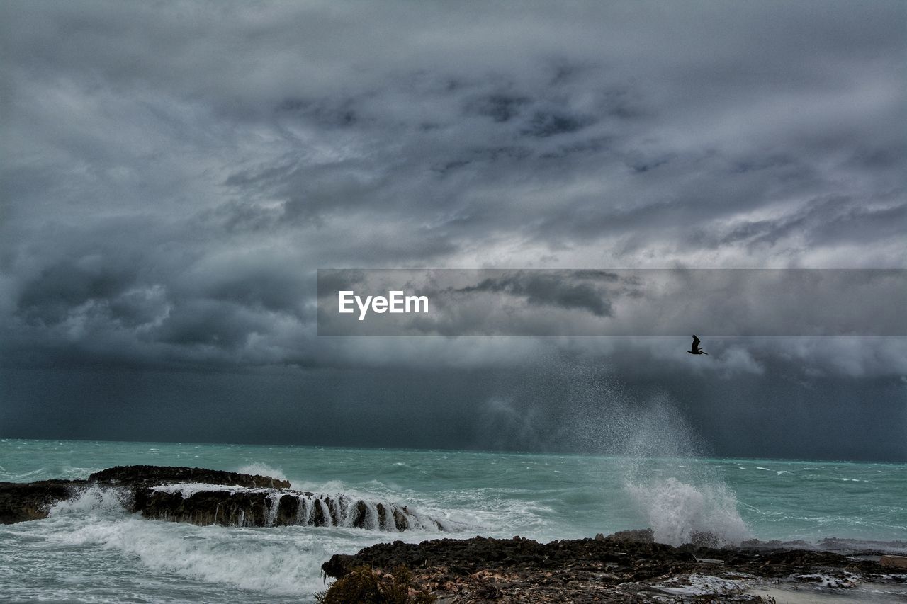 Scenic view of sea against storm clouds